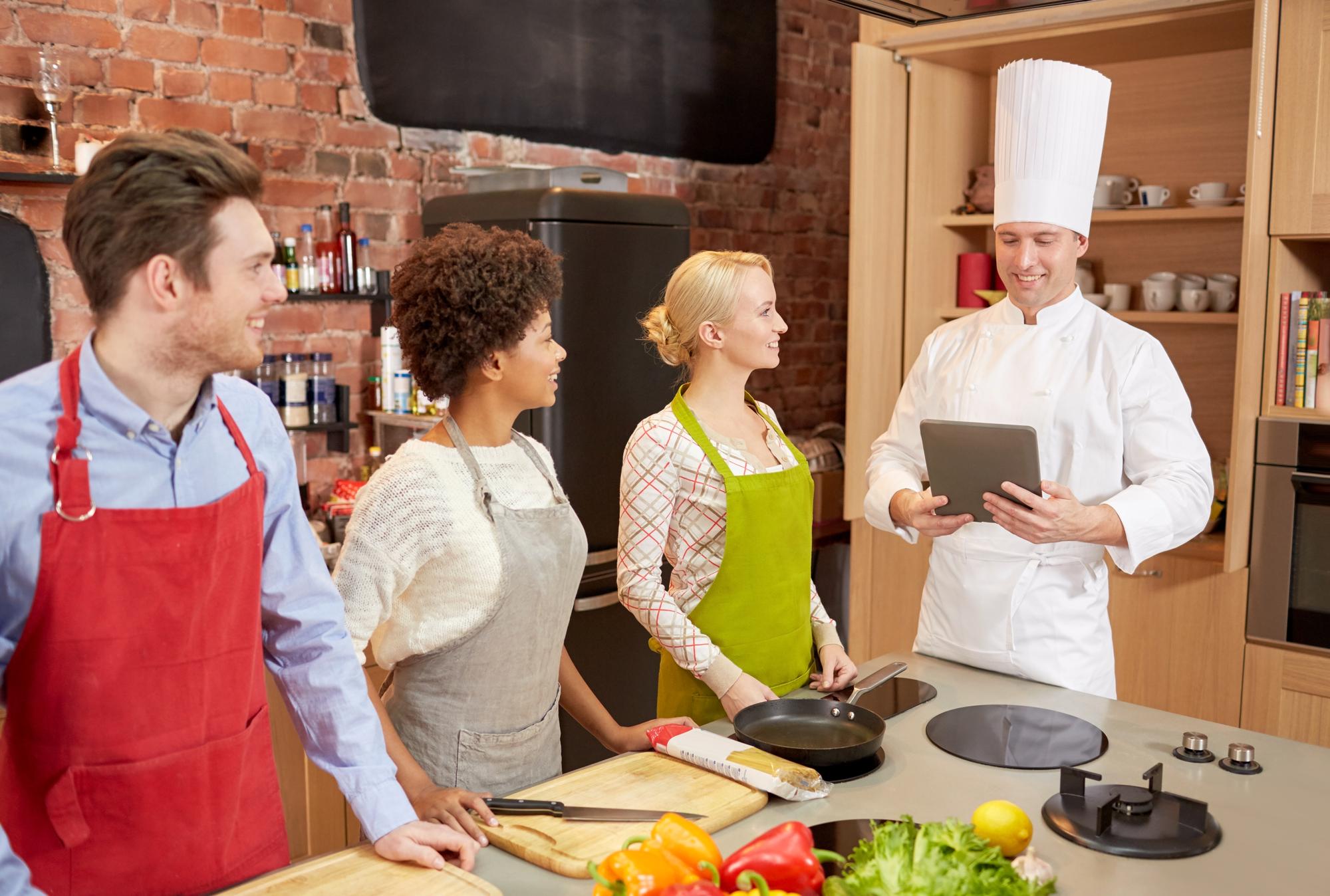 Chef consulting with team in kitchen